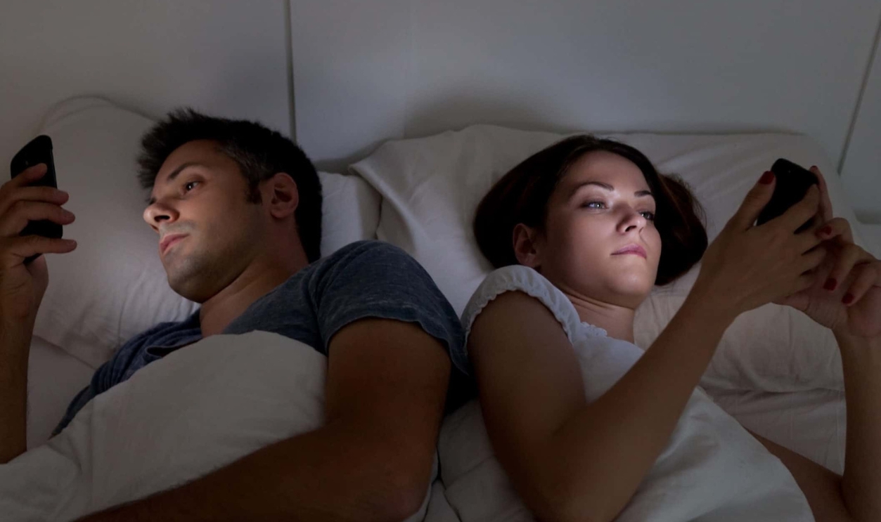 Young couple with smartphones in their bed, Shutterstock, 338717978