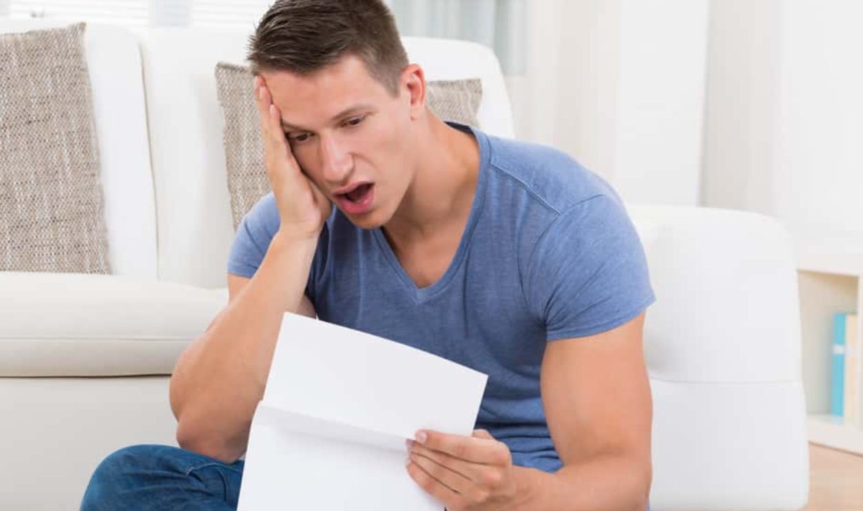 Shocked Young Man Looking At Paper, Shutterstock, 317352848