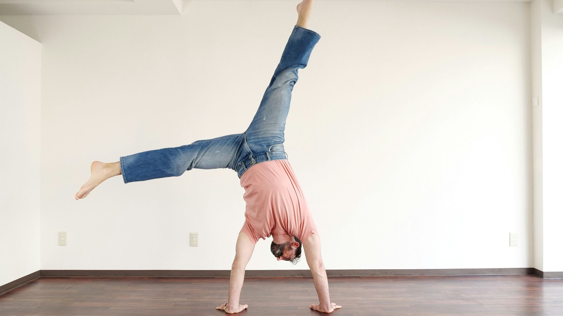 a person doing a handstand on a hard wood floor