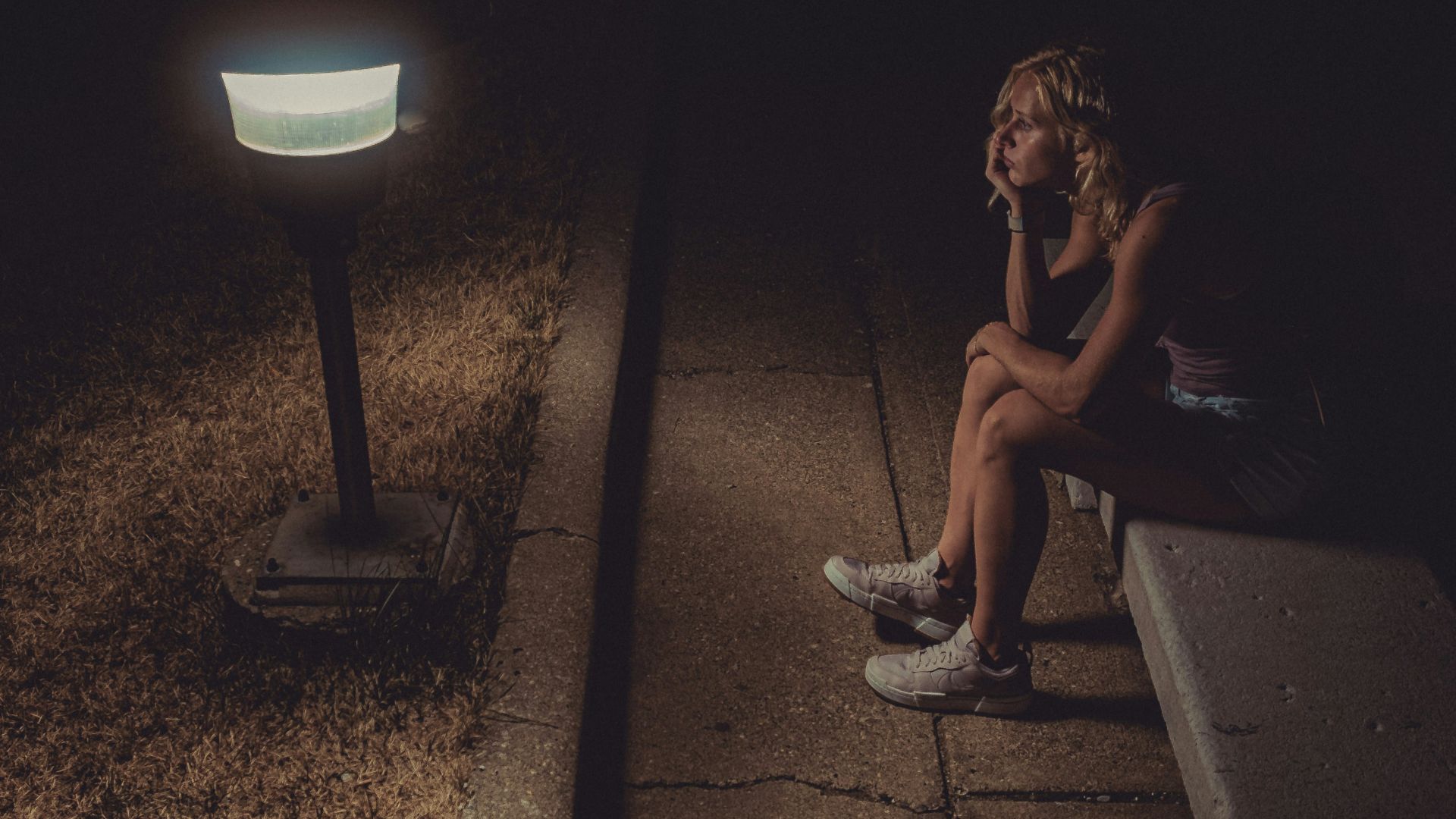 woman in black tank top sitting on concrete floor