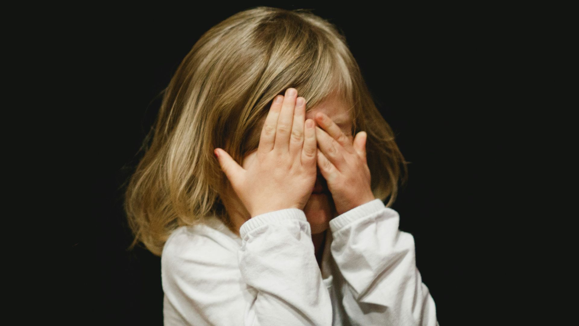 girl covering her face with both hands