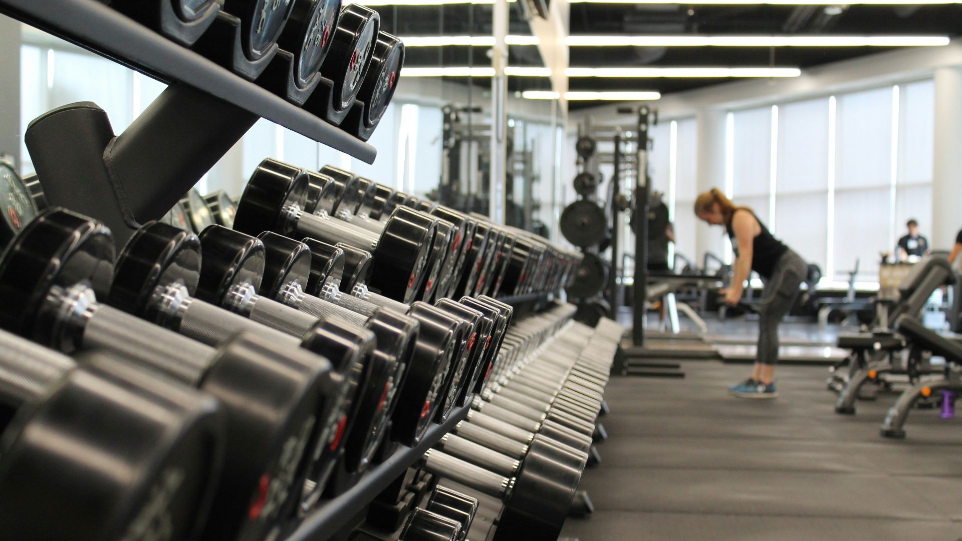 woman standing surrounded by exercise equipment