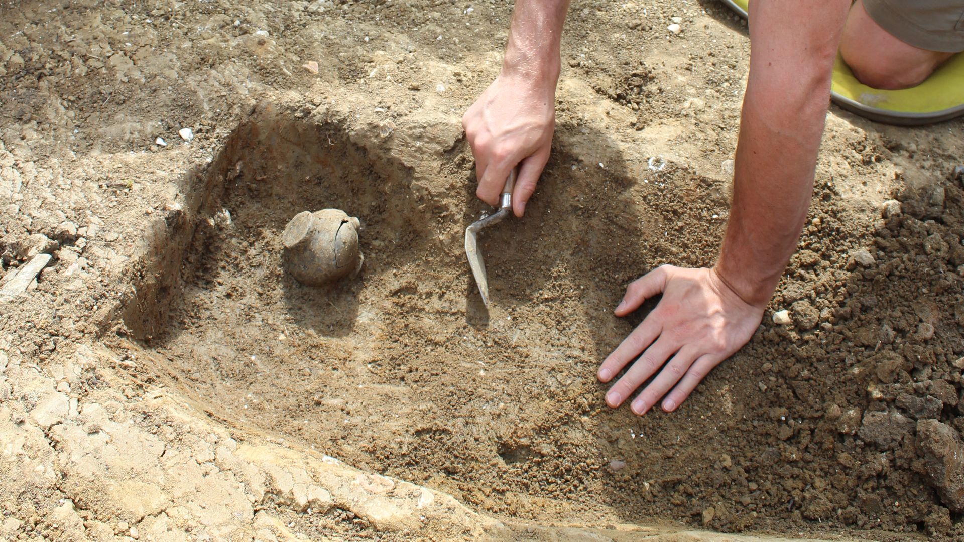 File:Archaeologist excavating a pot.jpg