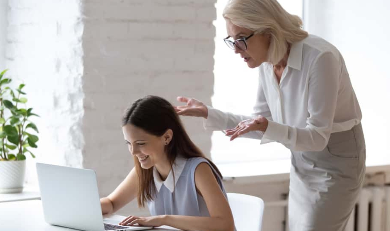 Worker Typing On Pc, Employer Looks At Subordinate's Screen, Shutterstock, 1619862757