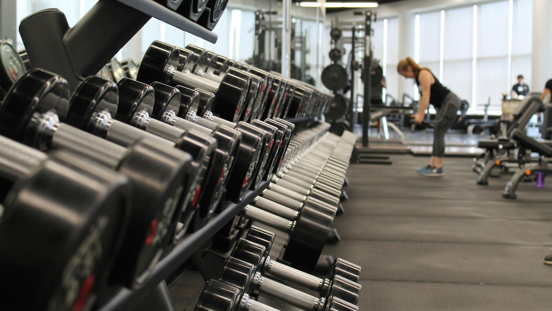 woman standing surrounded by exercise equipment