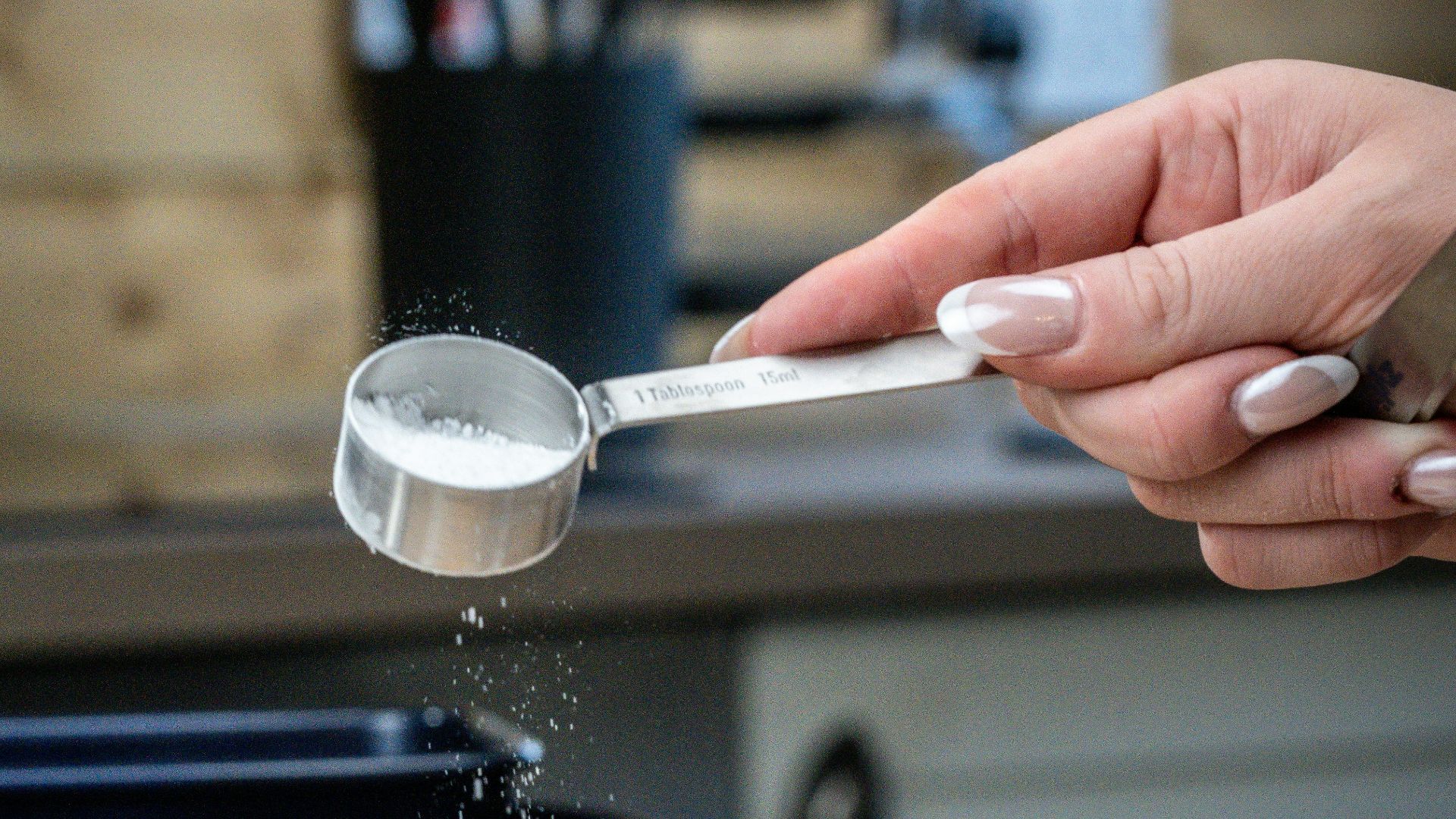 A person sprinkling sugar on a cake on a plate
