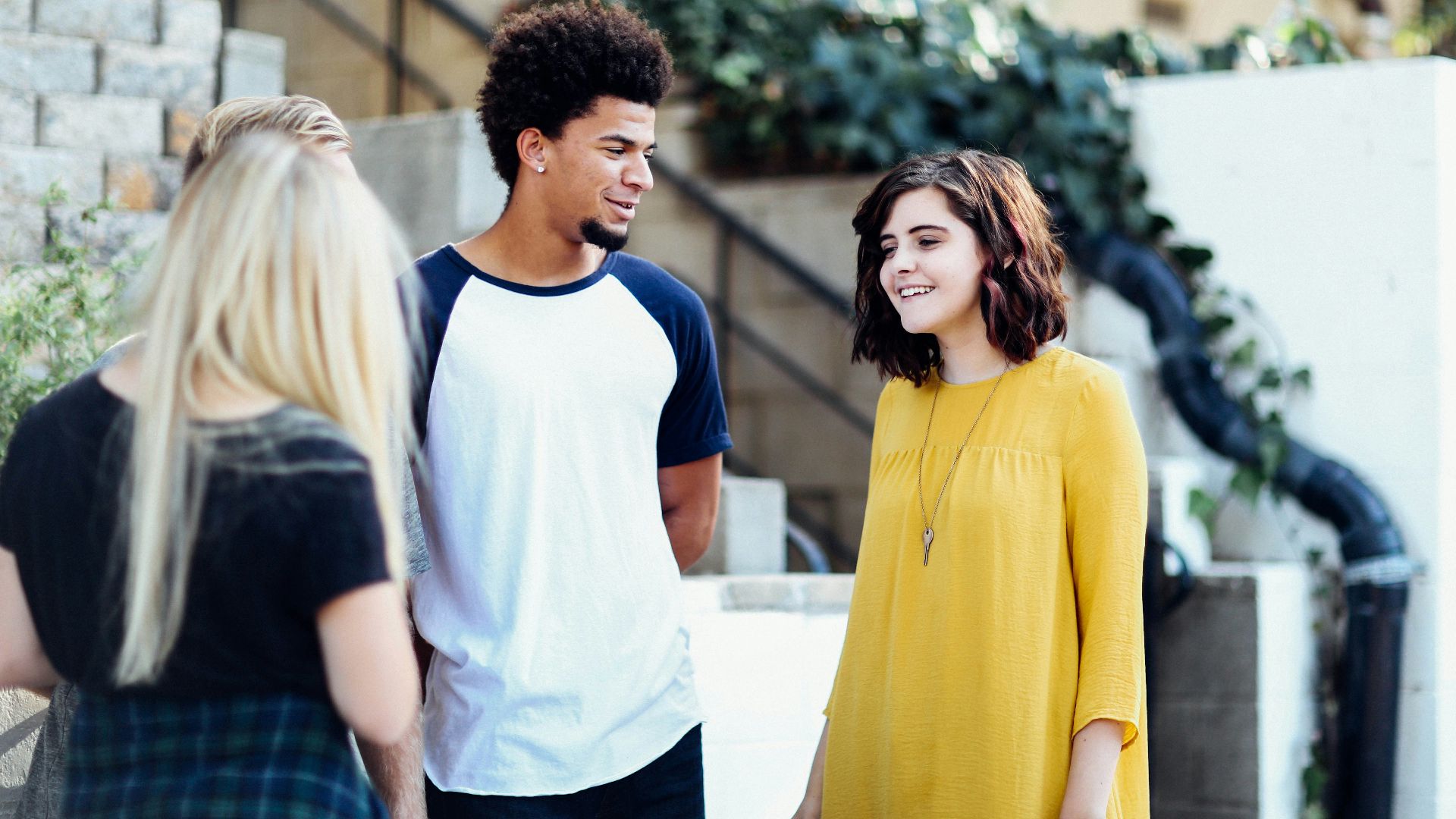 women and man talking outside the building