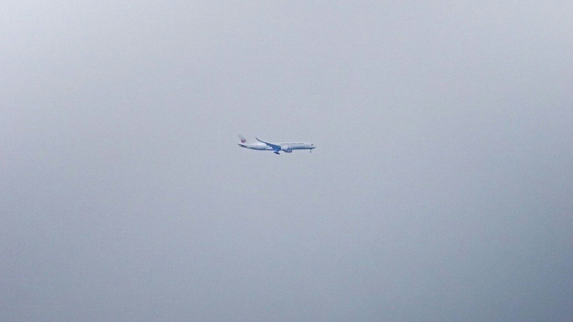 an airplane flying in the sky on a cloudy day