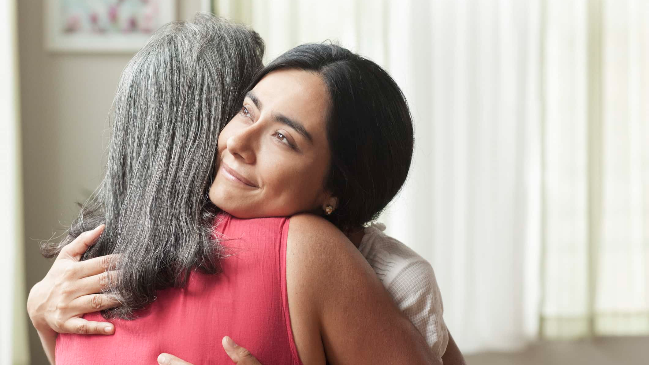 Smiling daughter hugging her mother