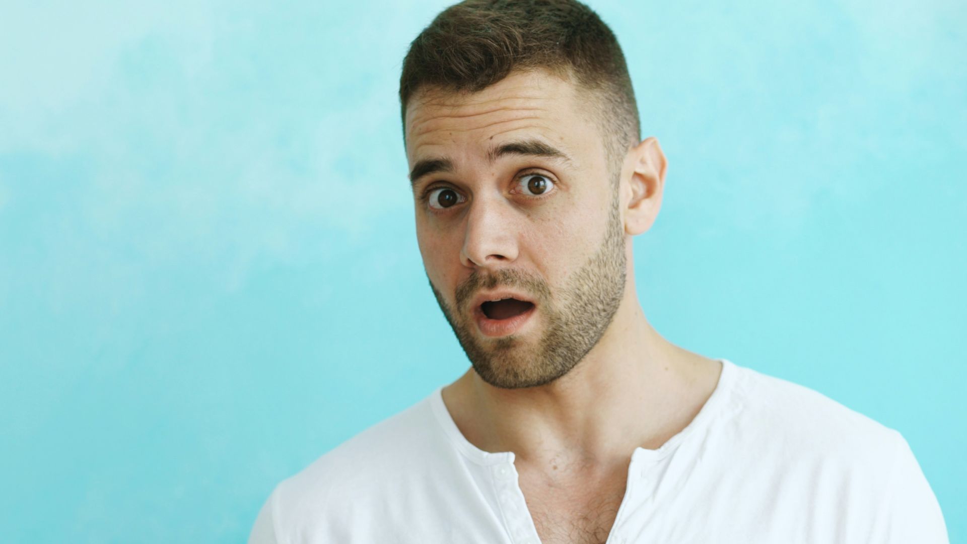 Man with surprised expression against blue background