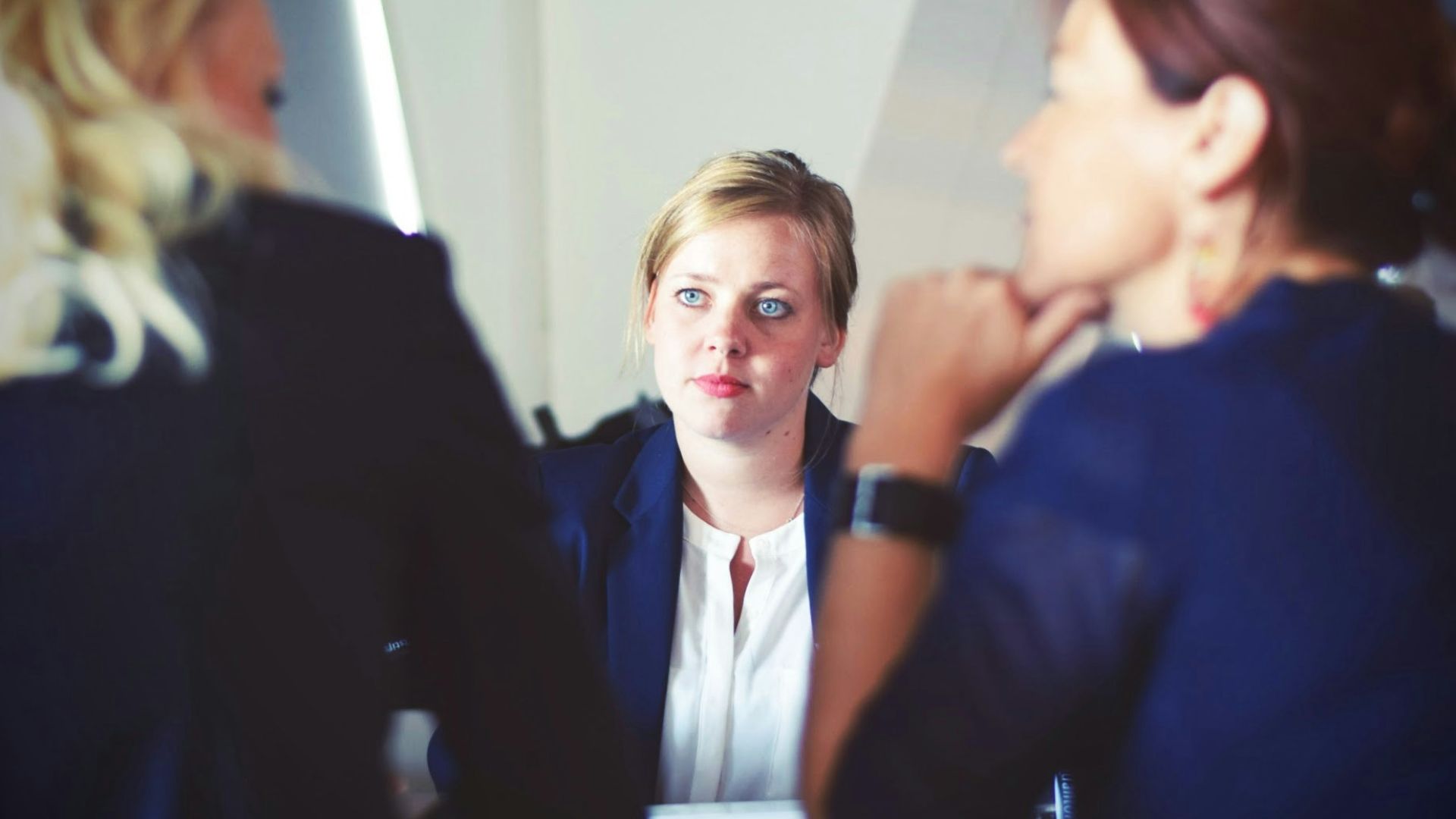 three women sitting beside table