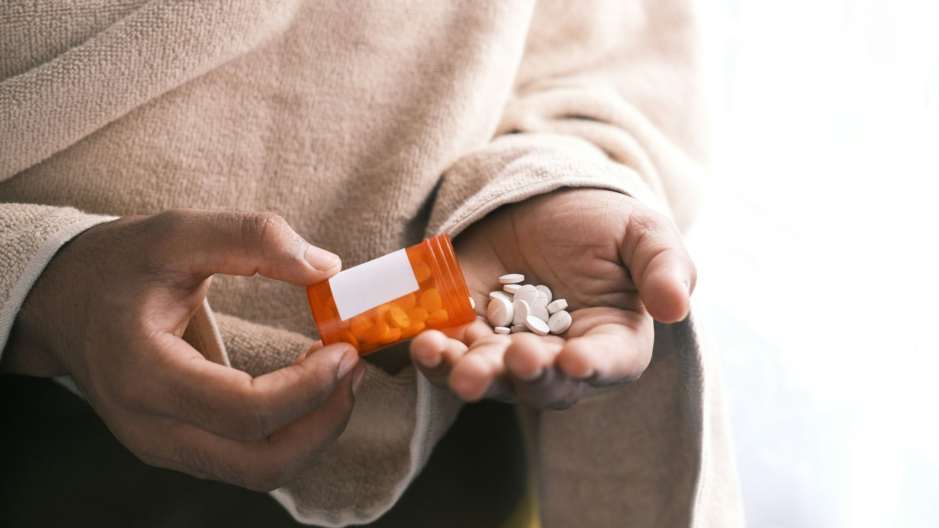 orange and white plastic bottle on white textile