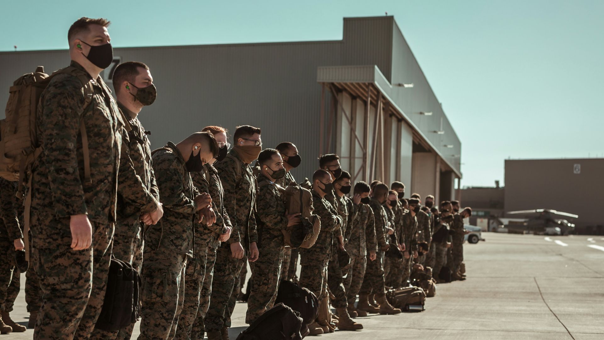 men in black and brown camouflage uniform standing on brown floor