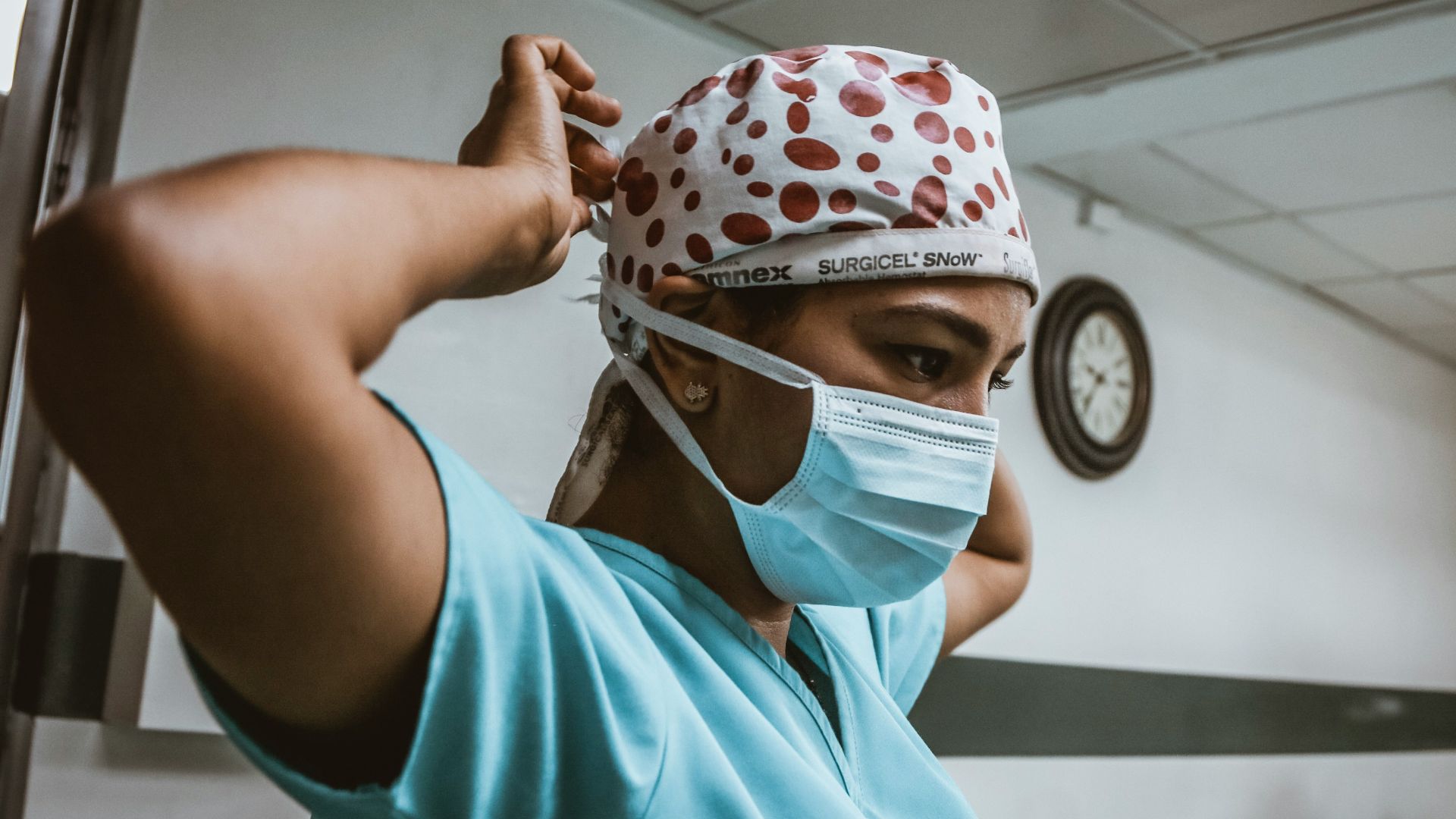 woman in teal shirt wearing white mask