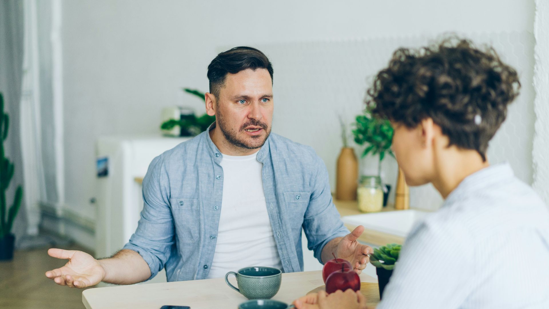 a man sitting at a table talking to a woman