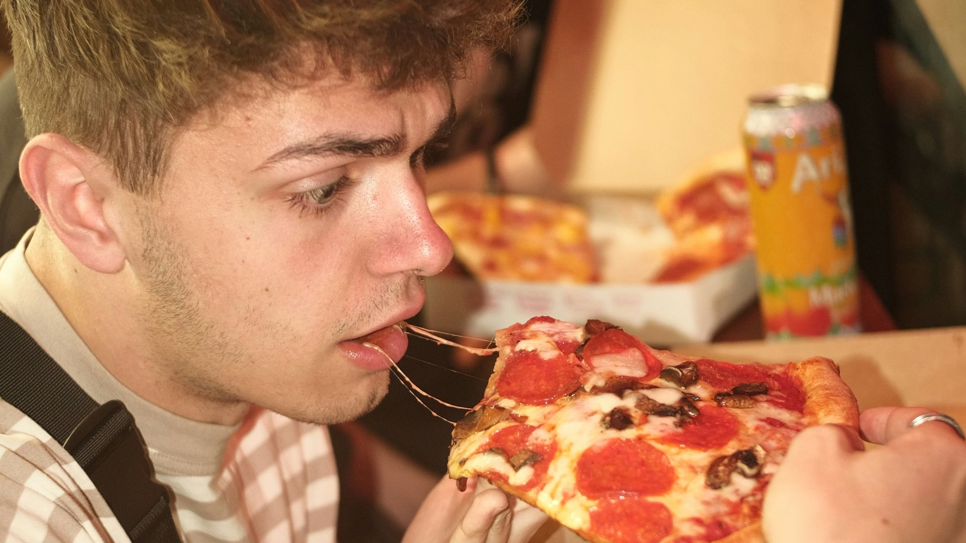a man eating a slice of pizza in a restaurant