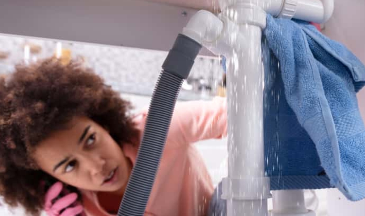 Woman Calling Plumber To Fix Sink Pipe, Shutterstock, 1295681308 (1)