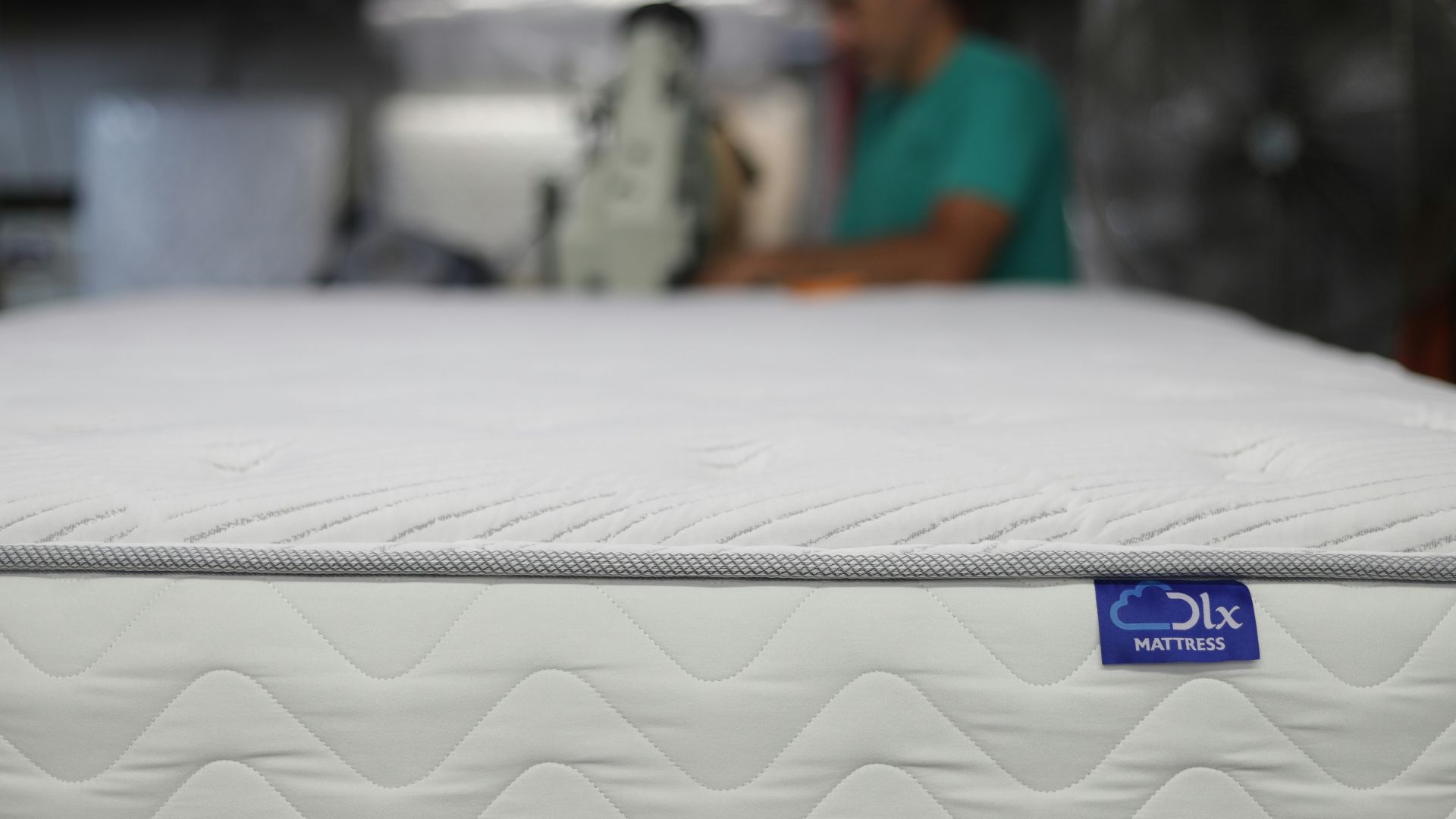 a man is working on a mattress in a warehouse