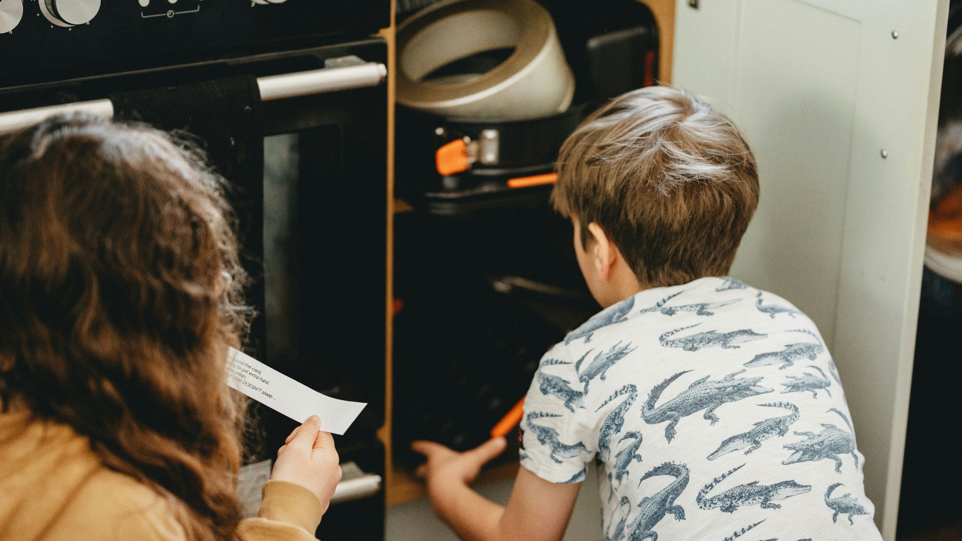 boy in white and black t-shirt sitting on chair