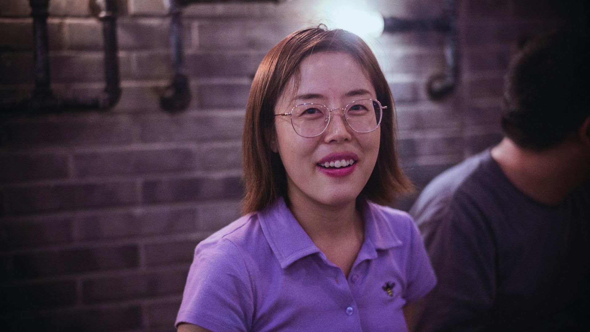 woman in purple polo shirt smiling