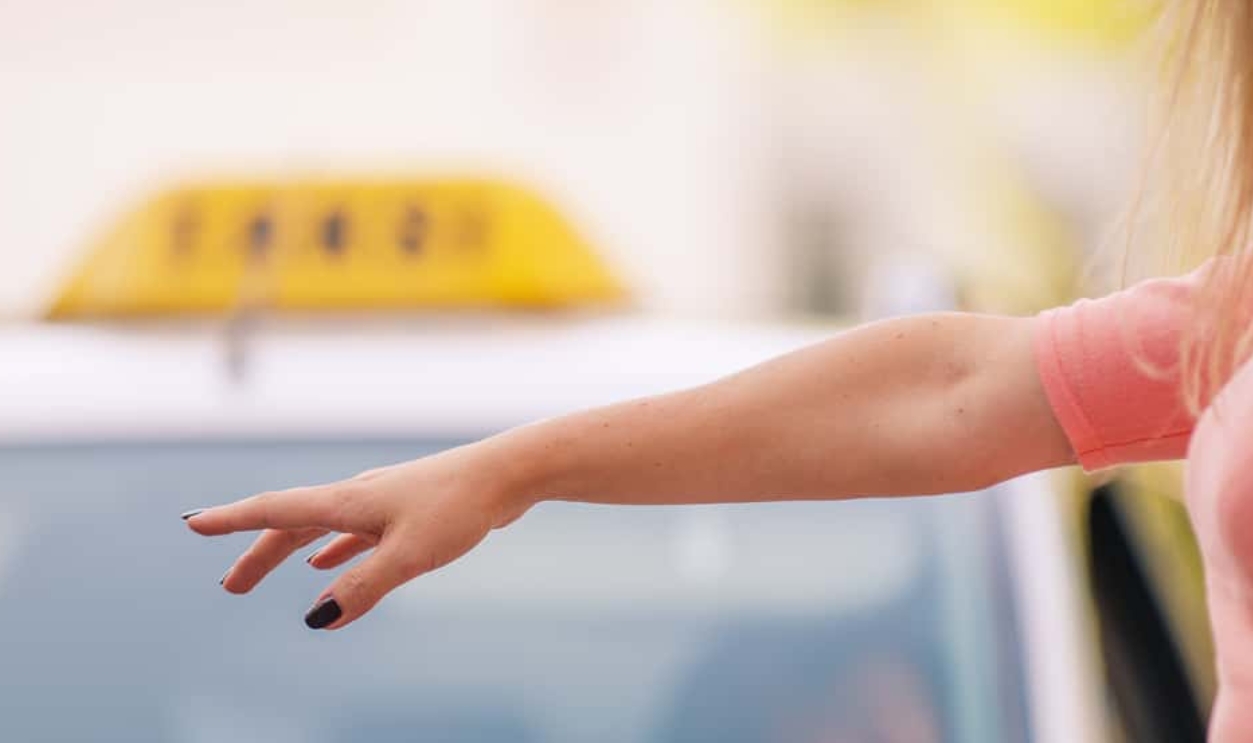 Woman Raising Her Arm To Call A Taxi, Shutterstock, 215412586