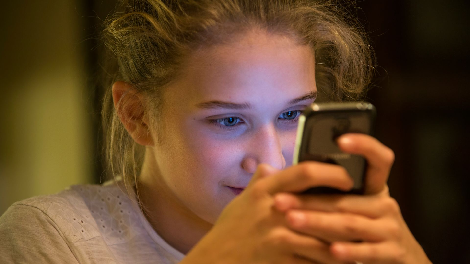 woman in gray top using smartphone
