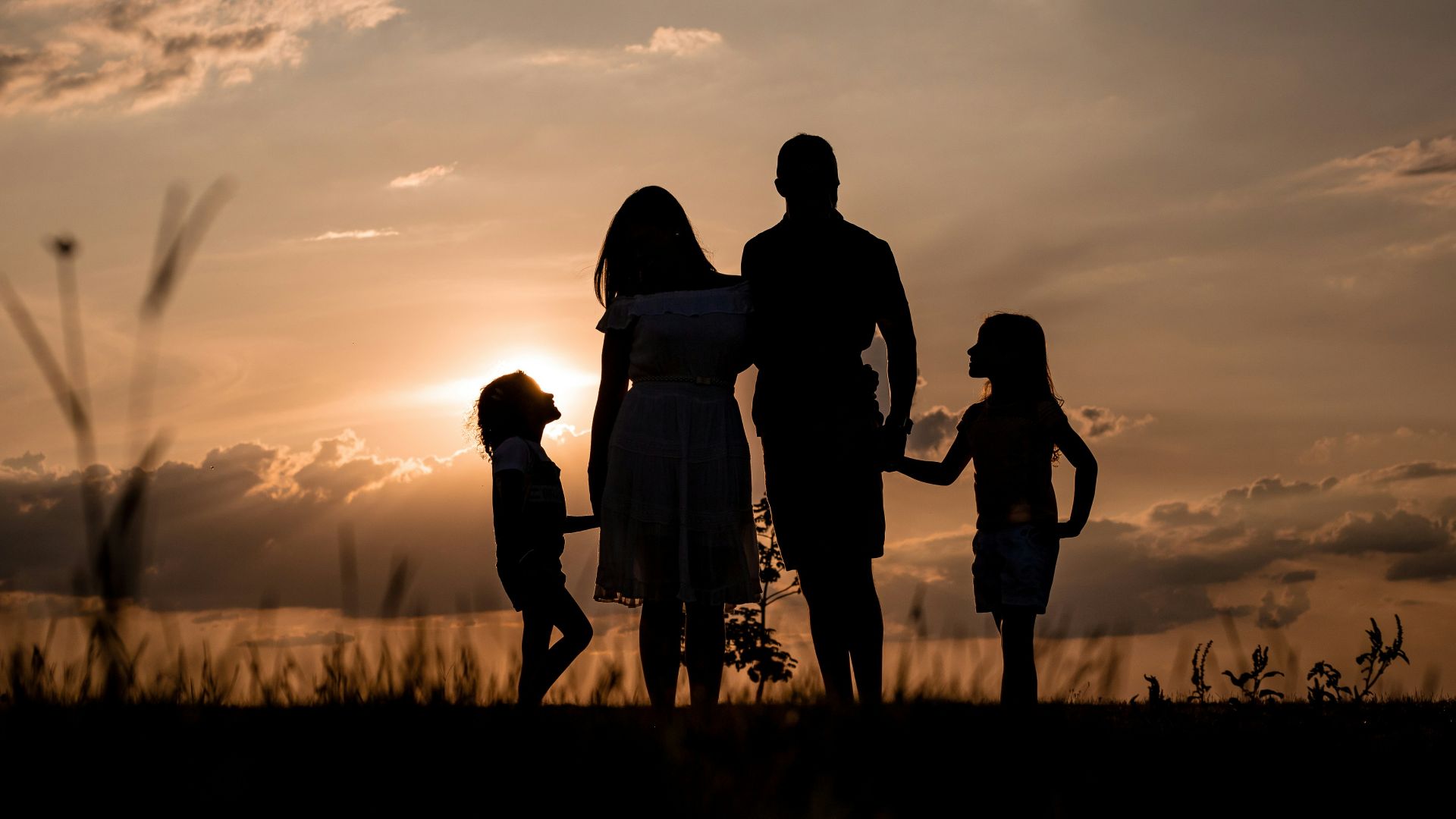 a family standing in a field at sunset