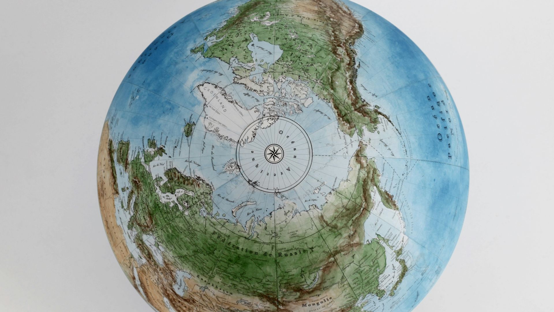 a blue and green globe sitting on top of a white table
