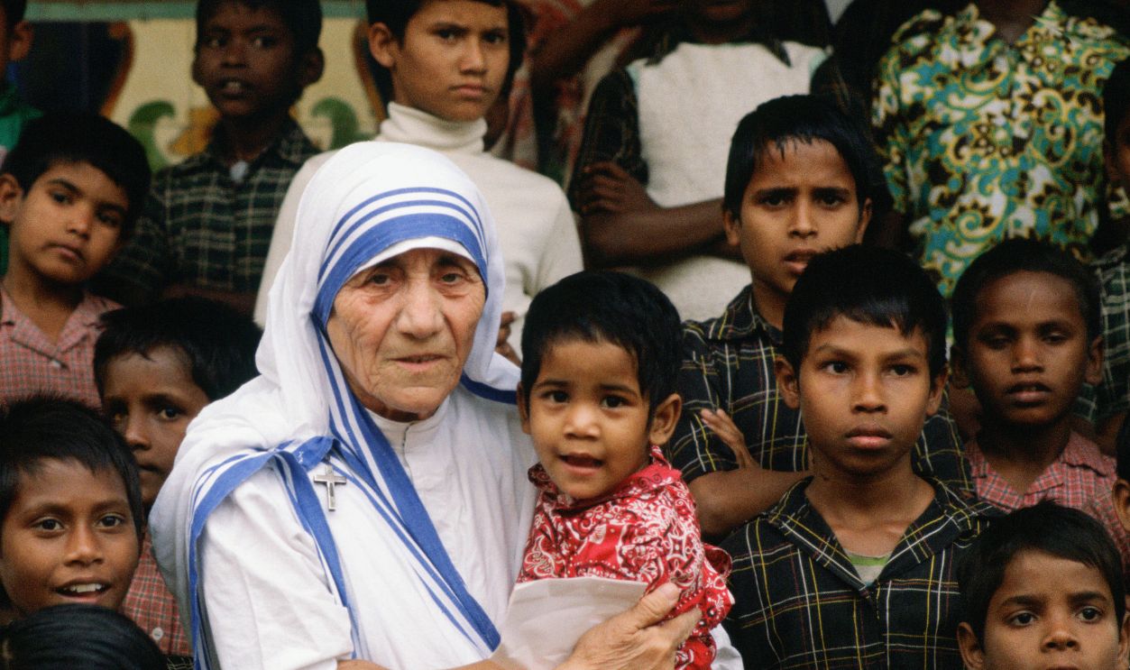 Mother Teresa accompanied by children at her mission in Calcutta, India.
