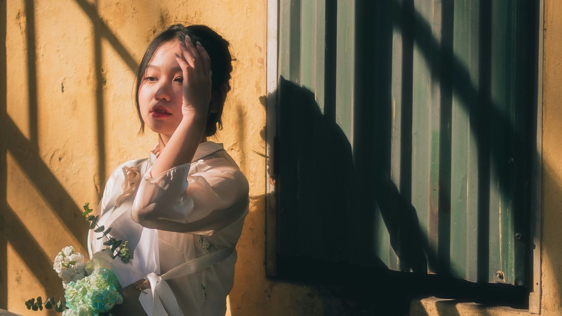 a woman sitting on the ground next to a building
