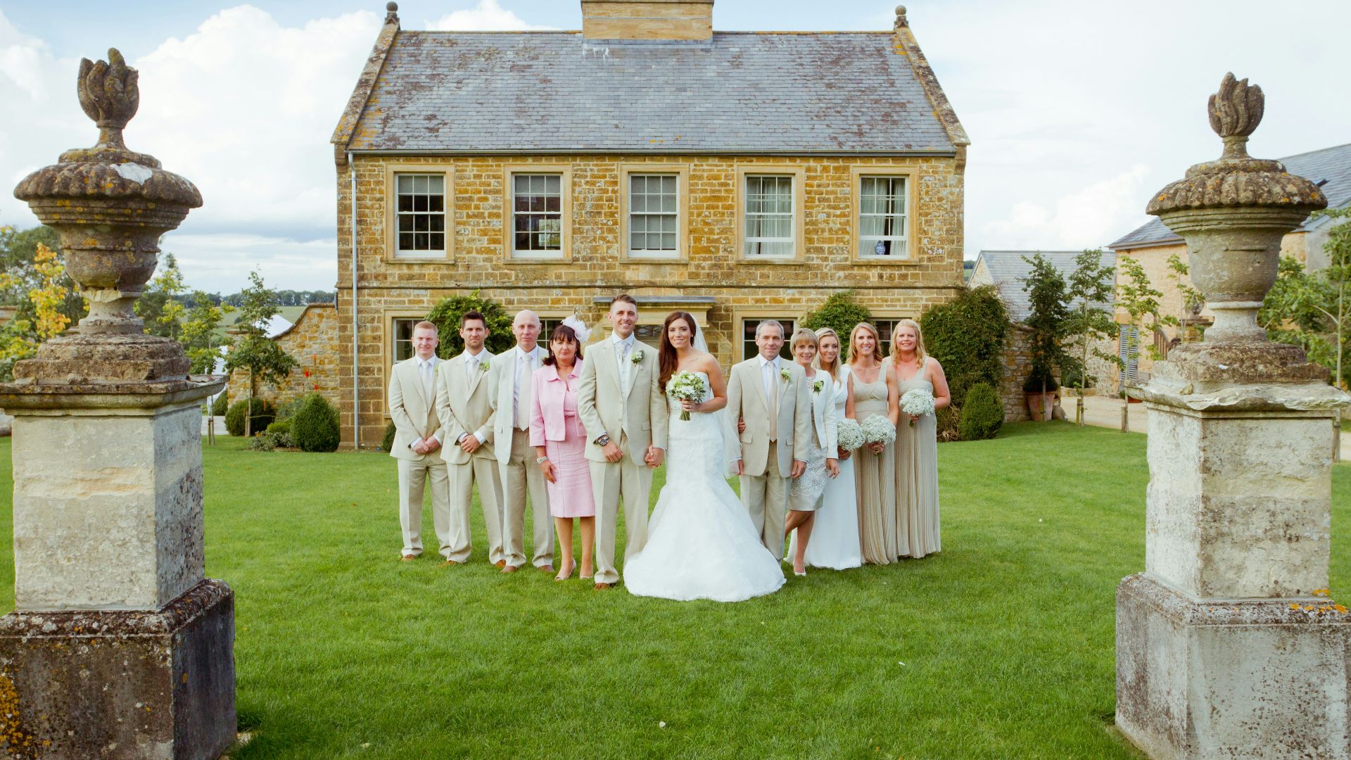 group of people standing on green grass field near brown brick house during daytime