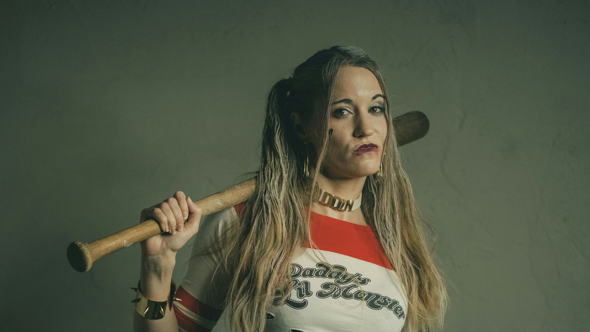 woman in white and red crop top and blue denim shorts holding brown wooden stick