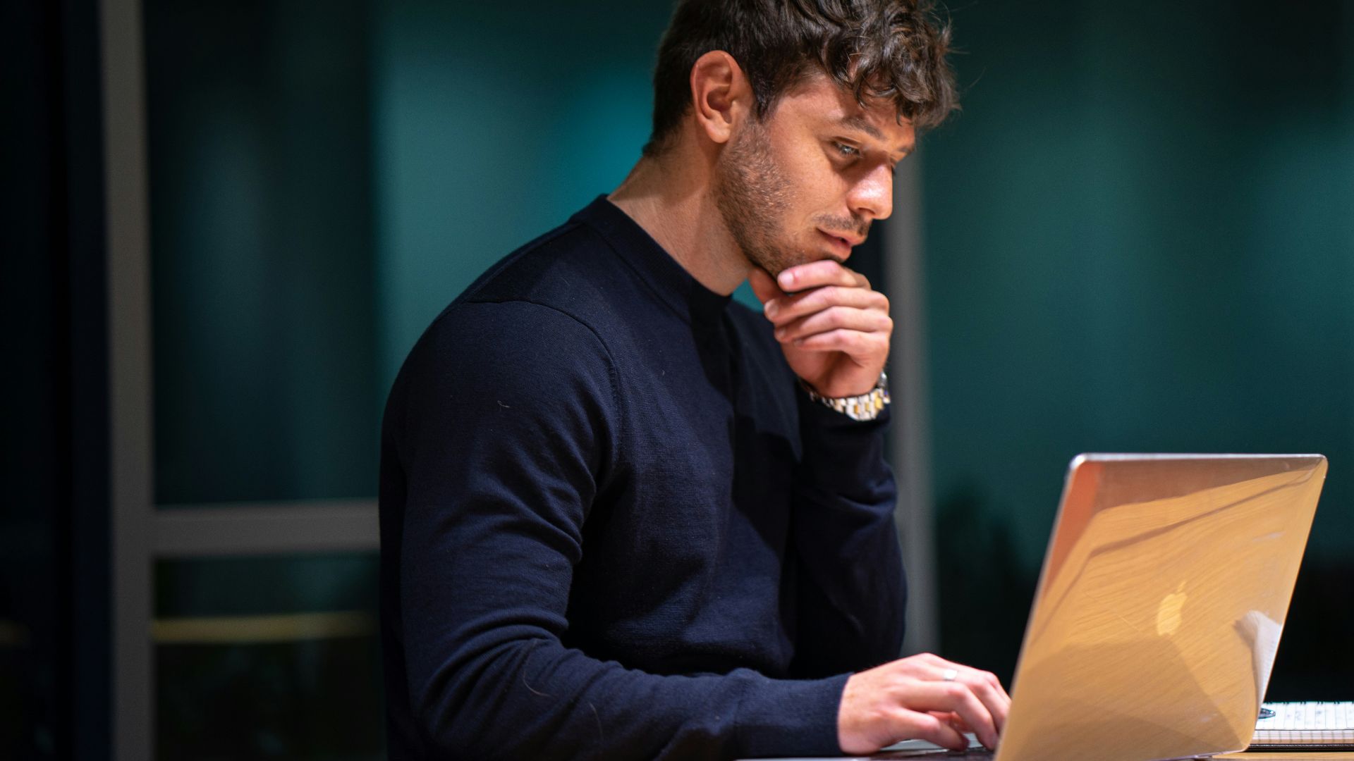 man in black long sleeve shirt sitting in front of macbook