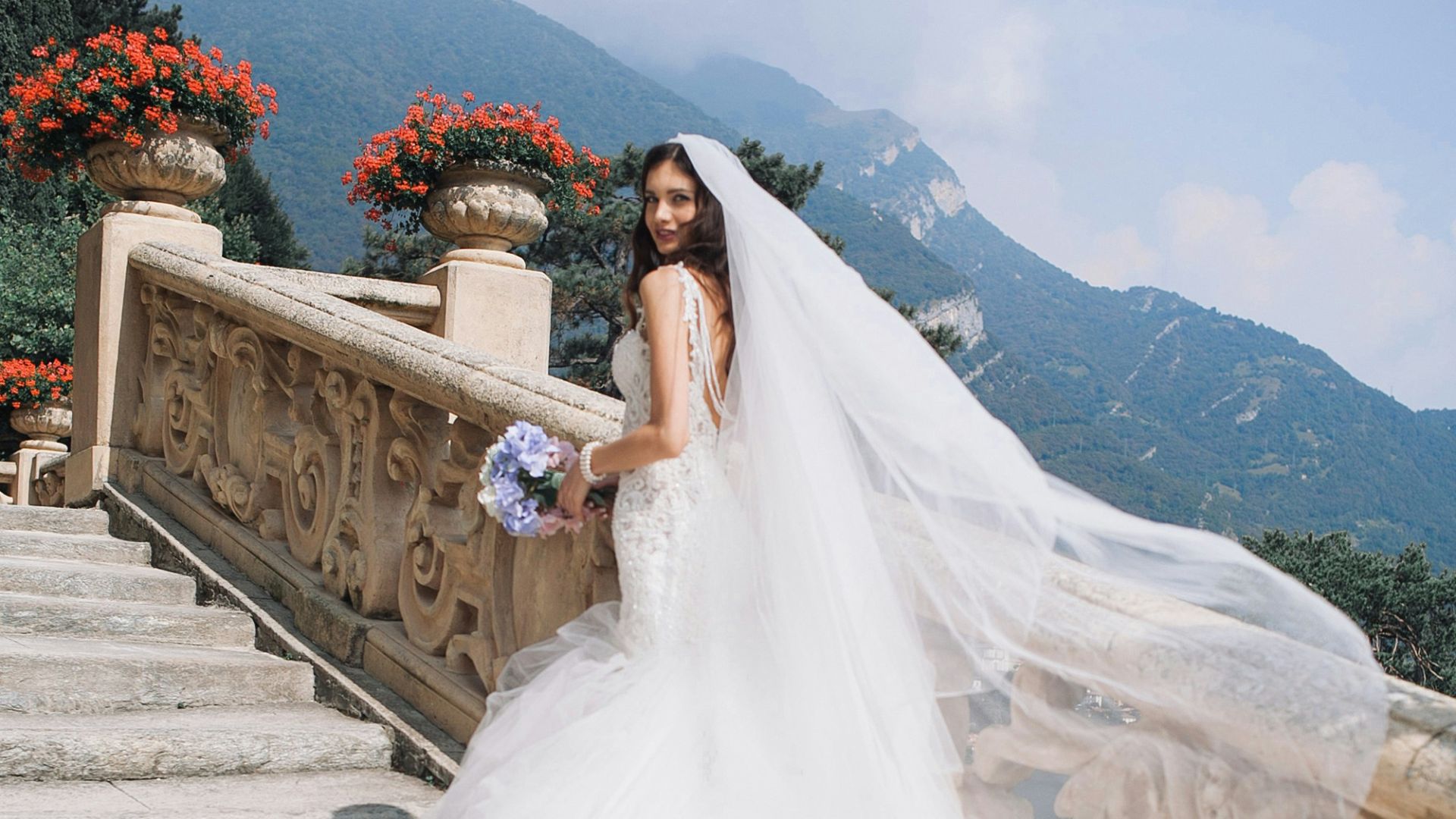 bride holding bouquet standing on white stairs