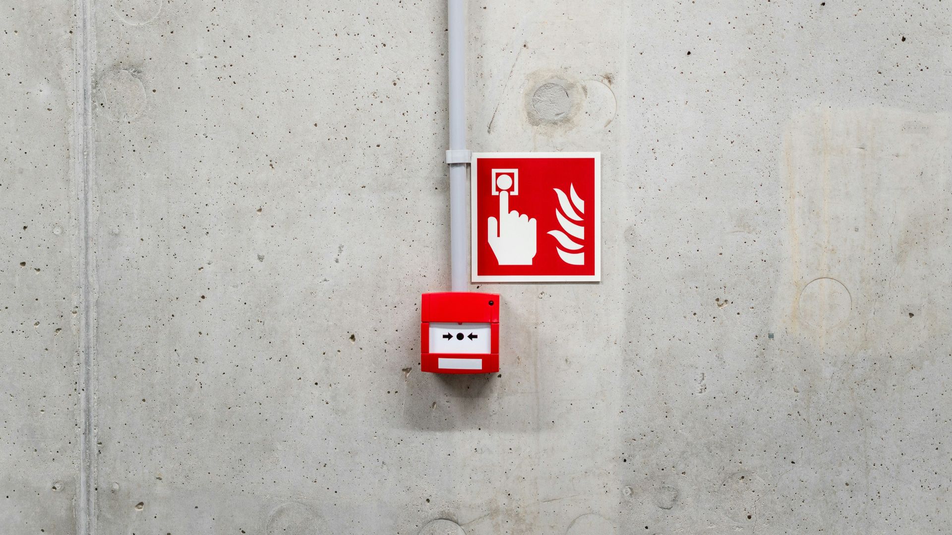 a red and white sign on a concrete wall