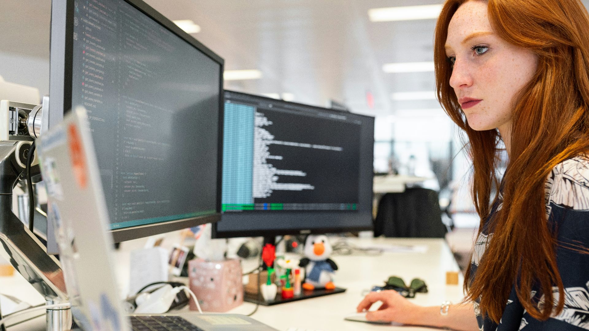 woman in green shirt sitting in front of computer