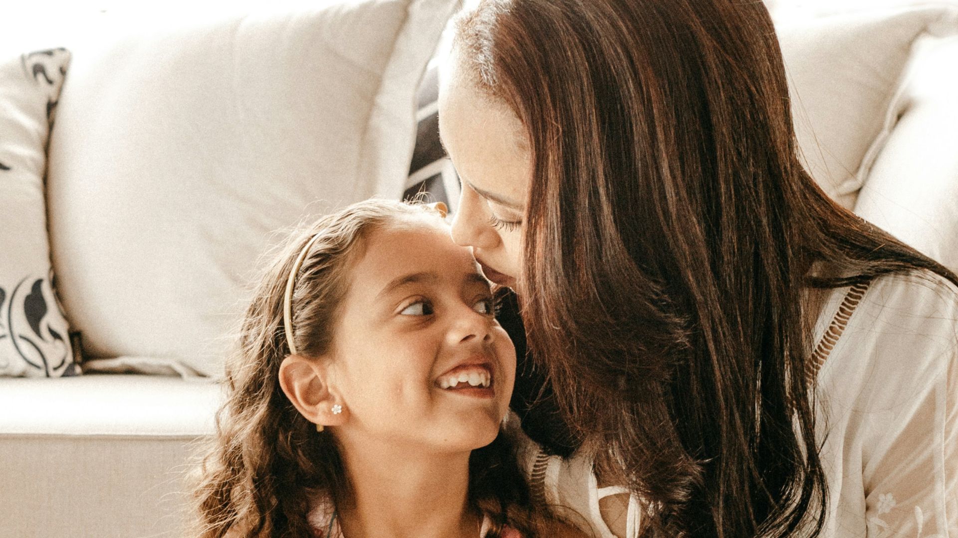 a woman sitting on the floor with a little girl