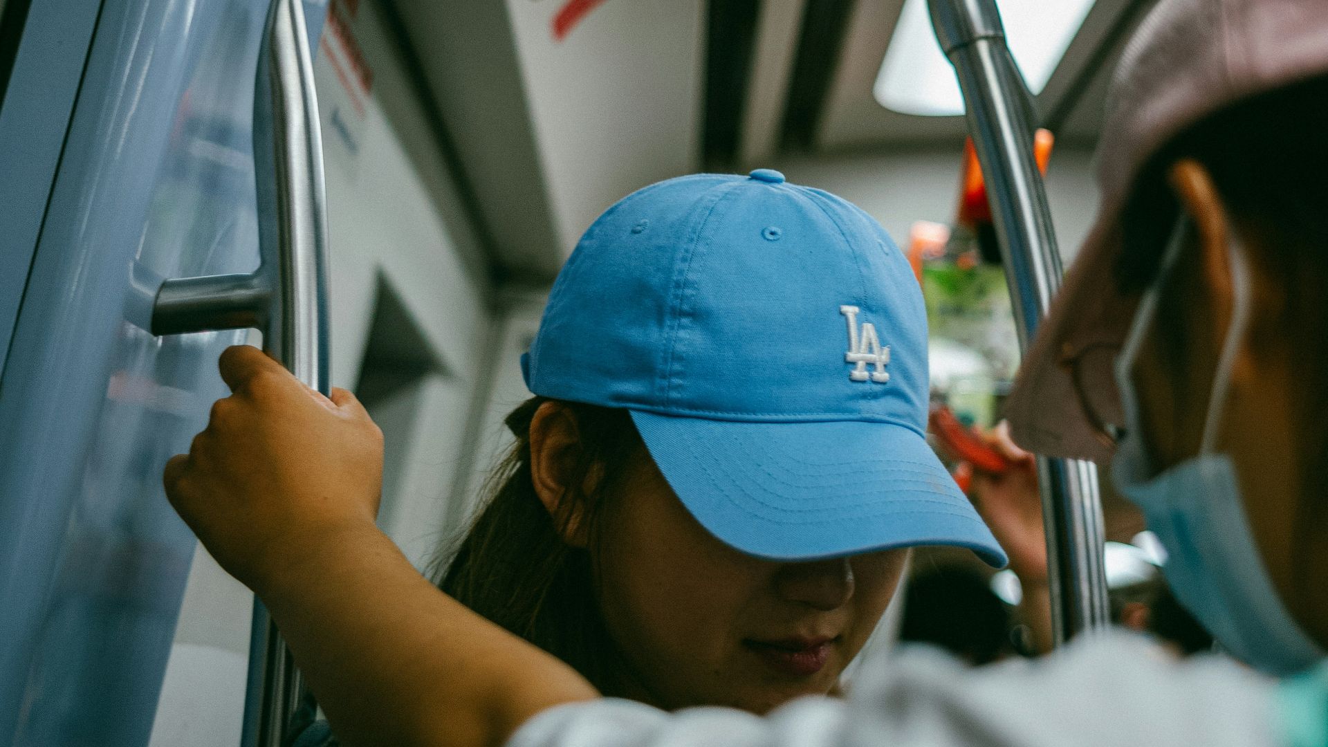 a woman in a blue hat is on a bus
