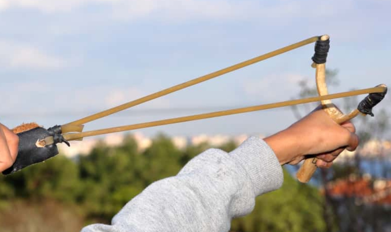 Human (Child) Is Throwing Stone With Slingshot, Shutterstock, 1247024413