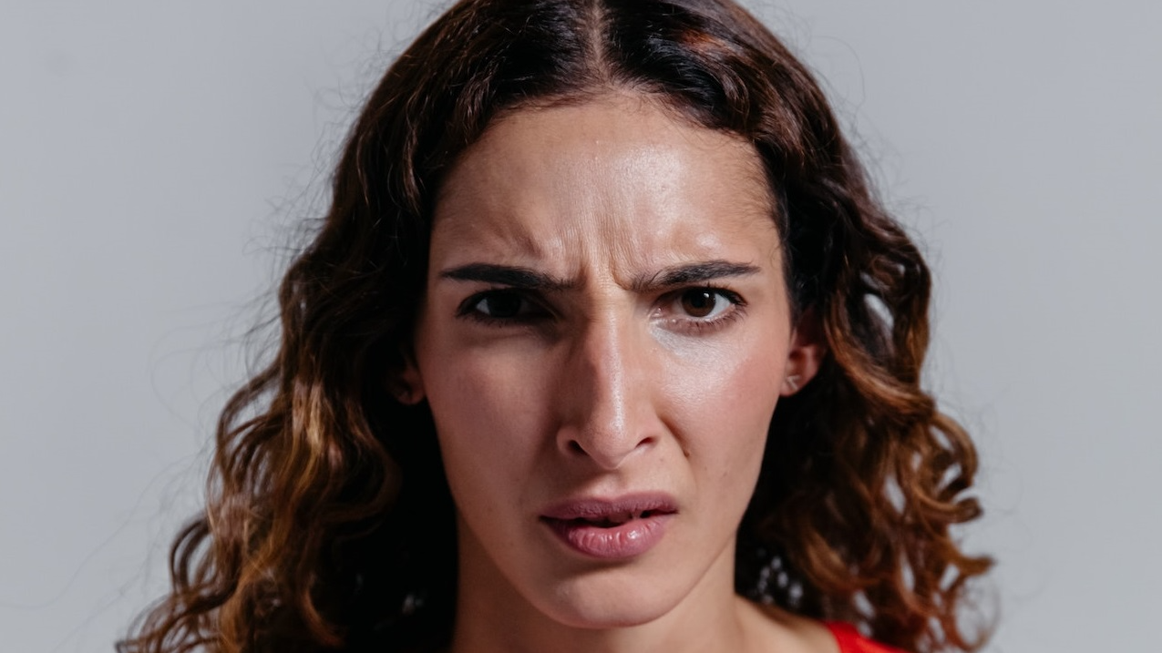 Angry woman with red sweater is looking at camera.