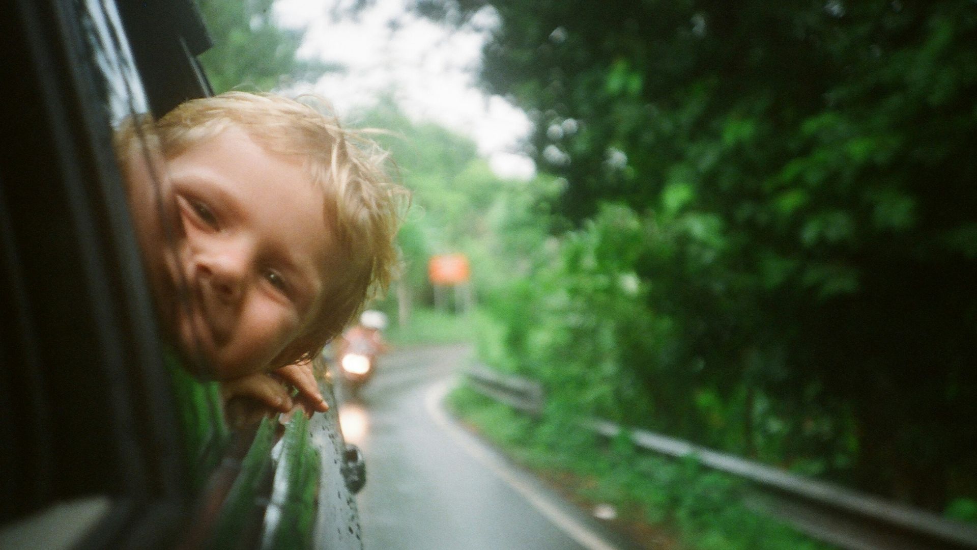 child peeking from vehicle window
