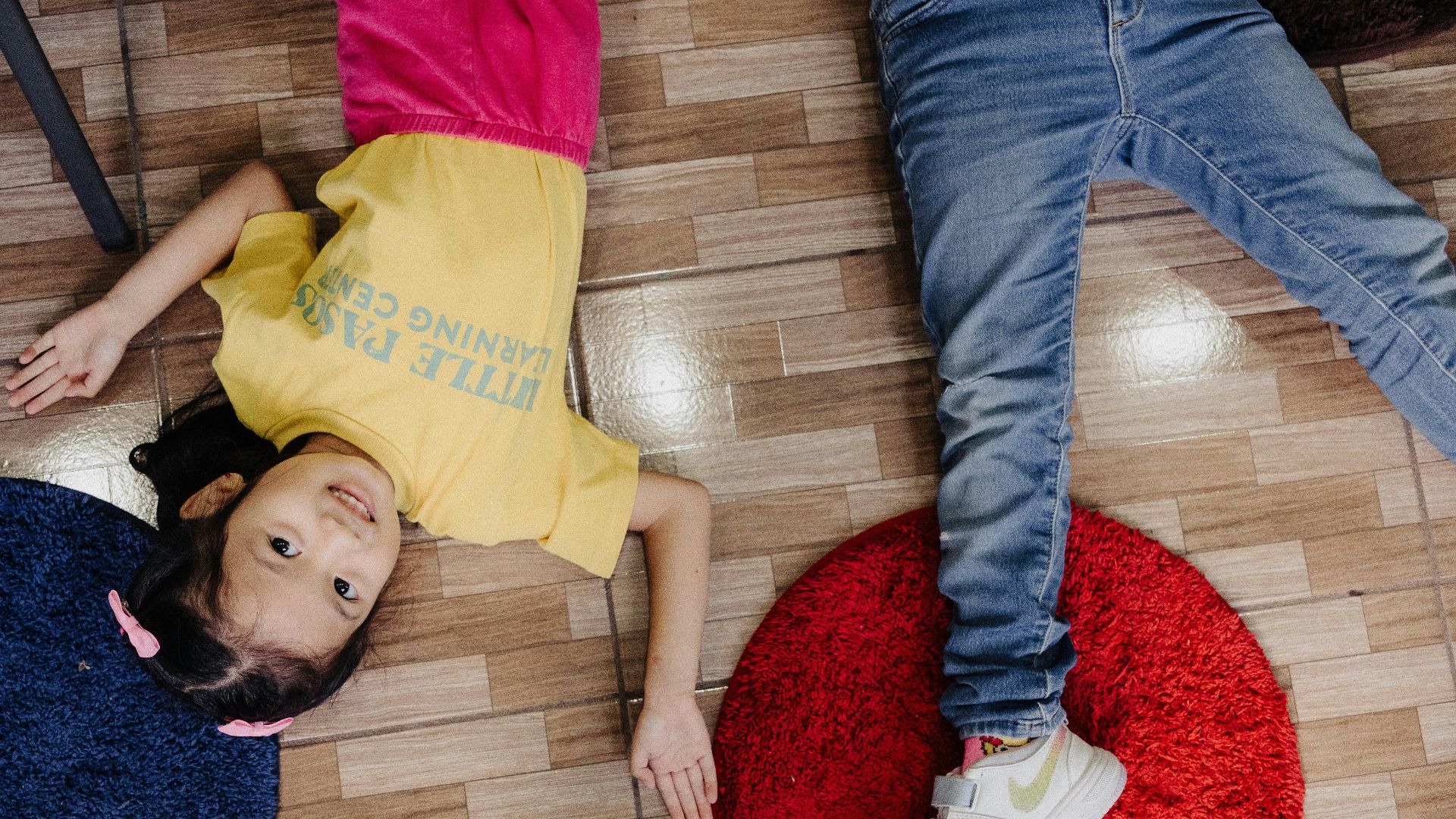 A group of people laying on top of a wooden floor