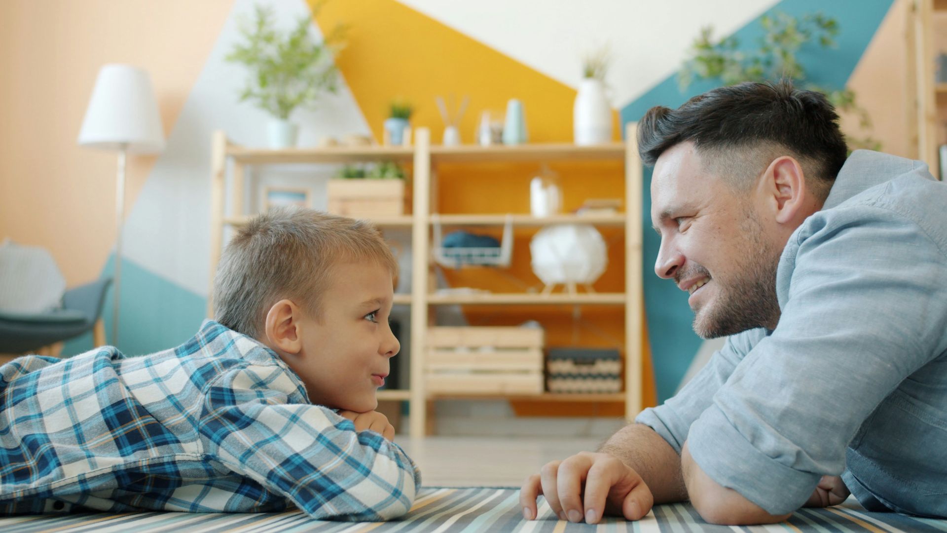 Father and son looking at each other on floor