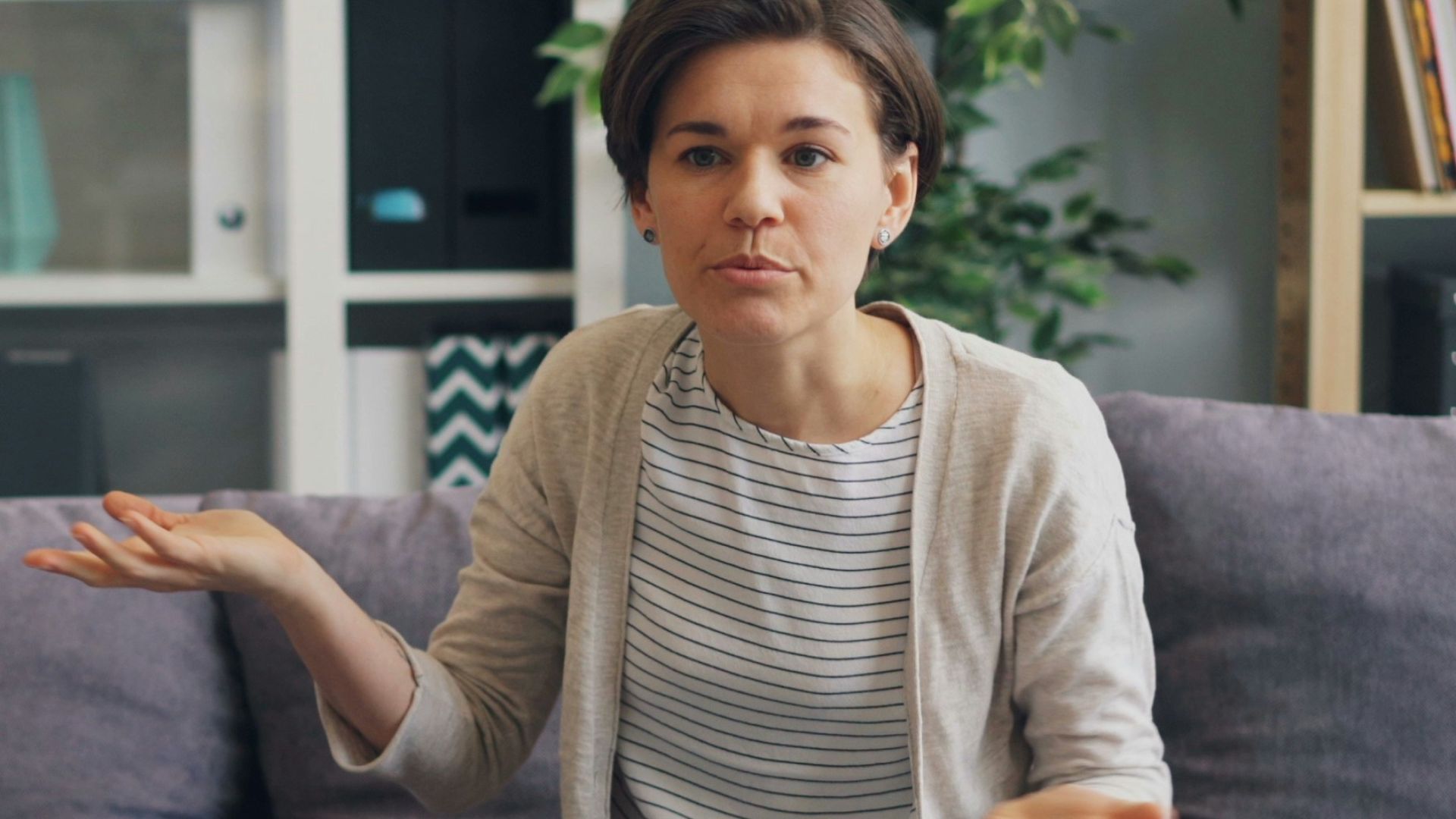a woman sitting on a couch talking to a man