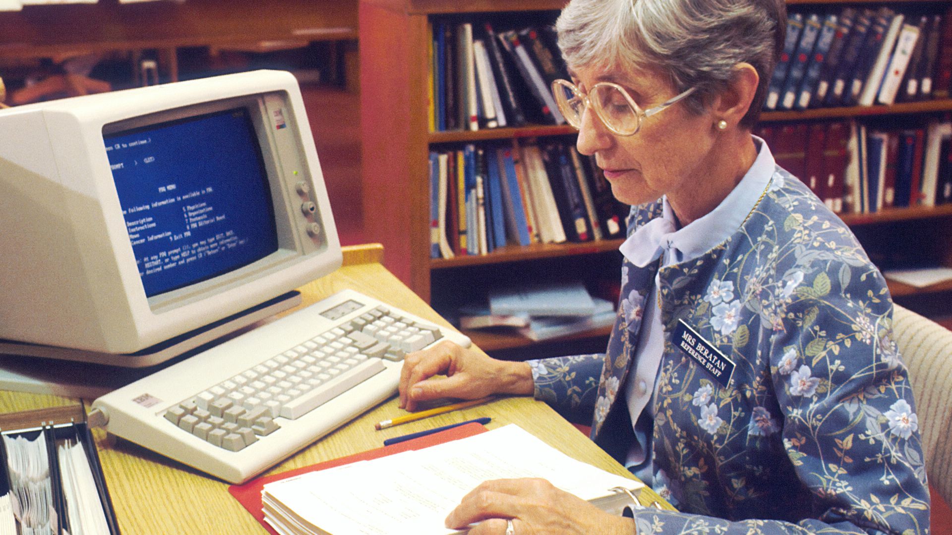 woman sitting at desk with desktop computer
