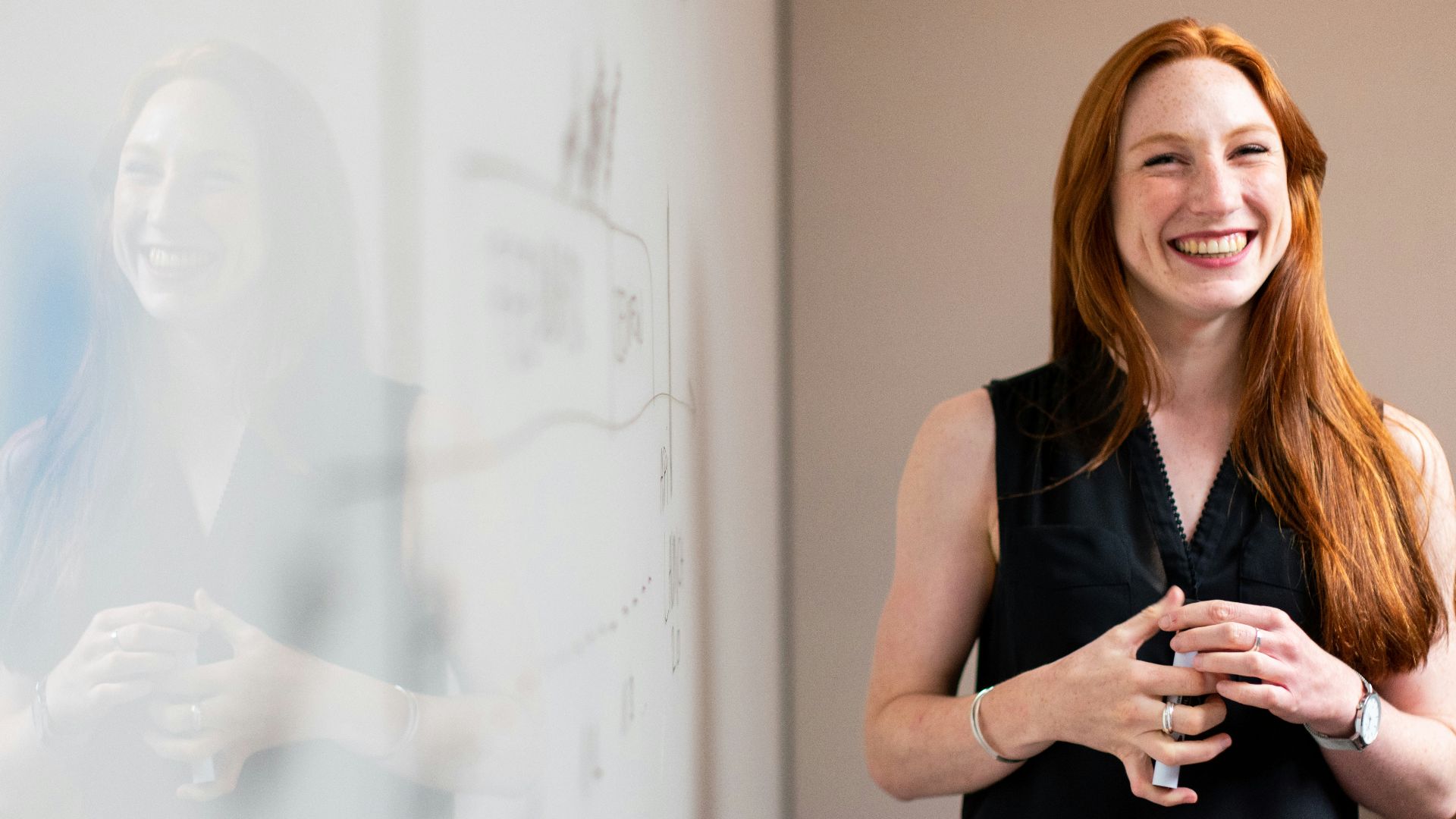 woman in blue tank top standing beside white wall