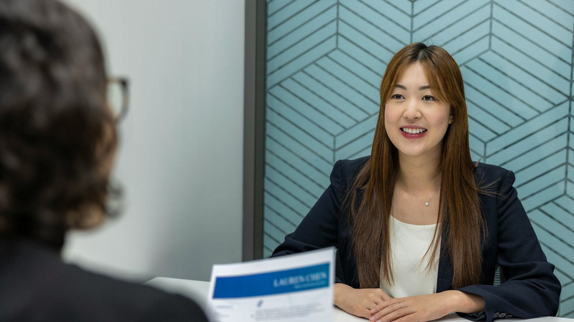 a woman sitting at a table with a piece of paper in front of her