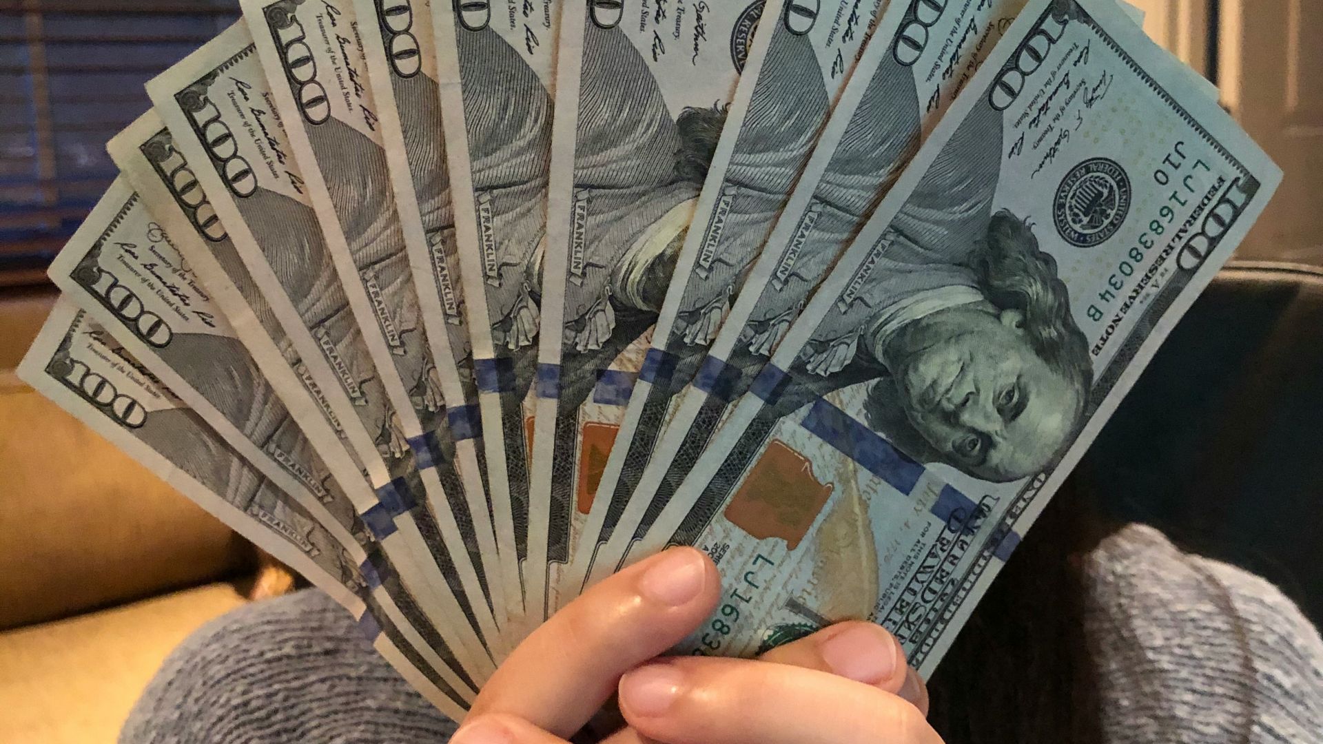 person holding fan of us dollar bill