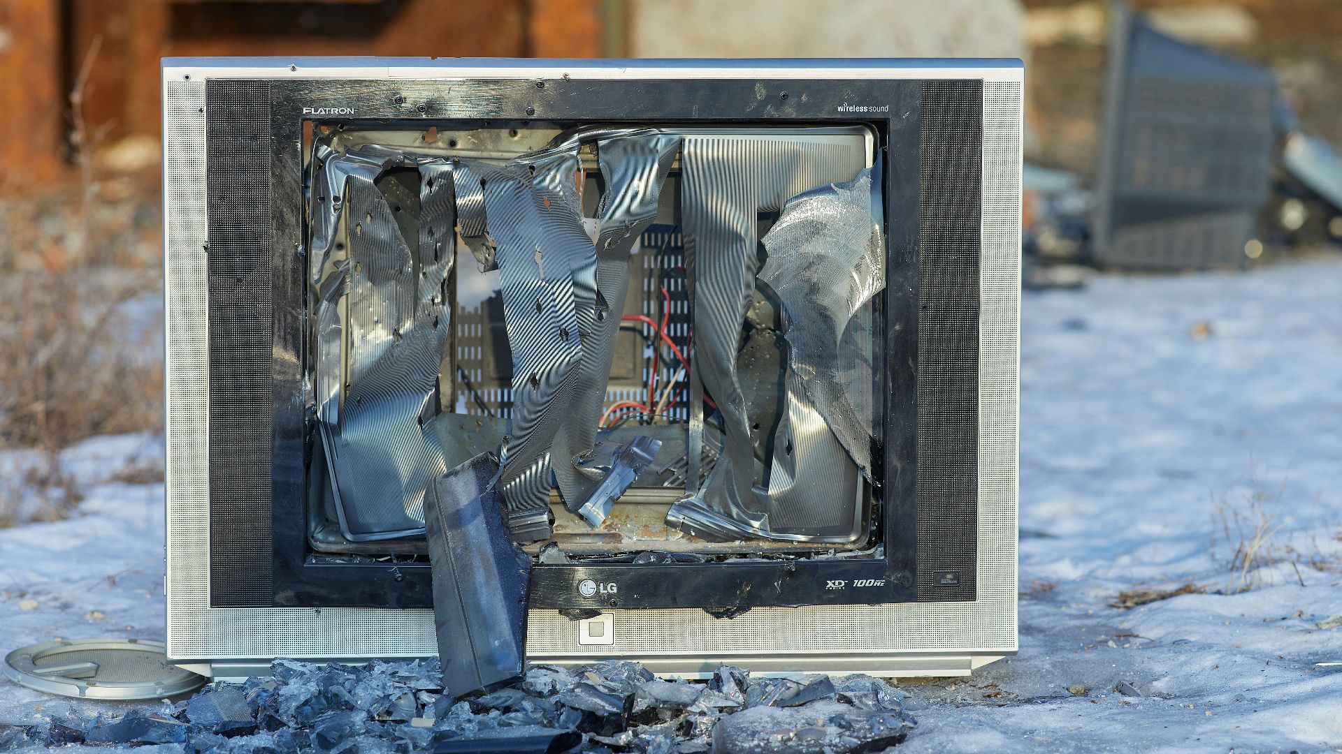 a broken television sitting on top of snow covered ground