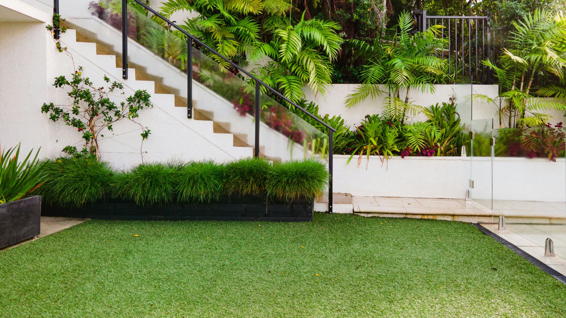 a white house with a green lawn and stairs